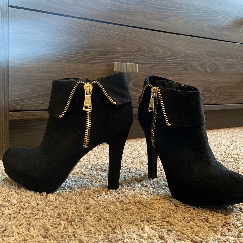 Black heeled booties with gold zipper by Guess
